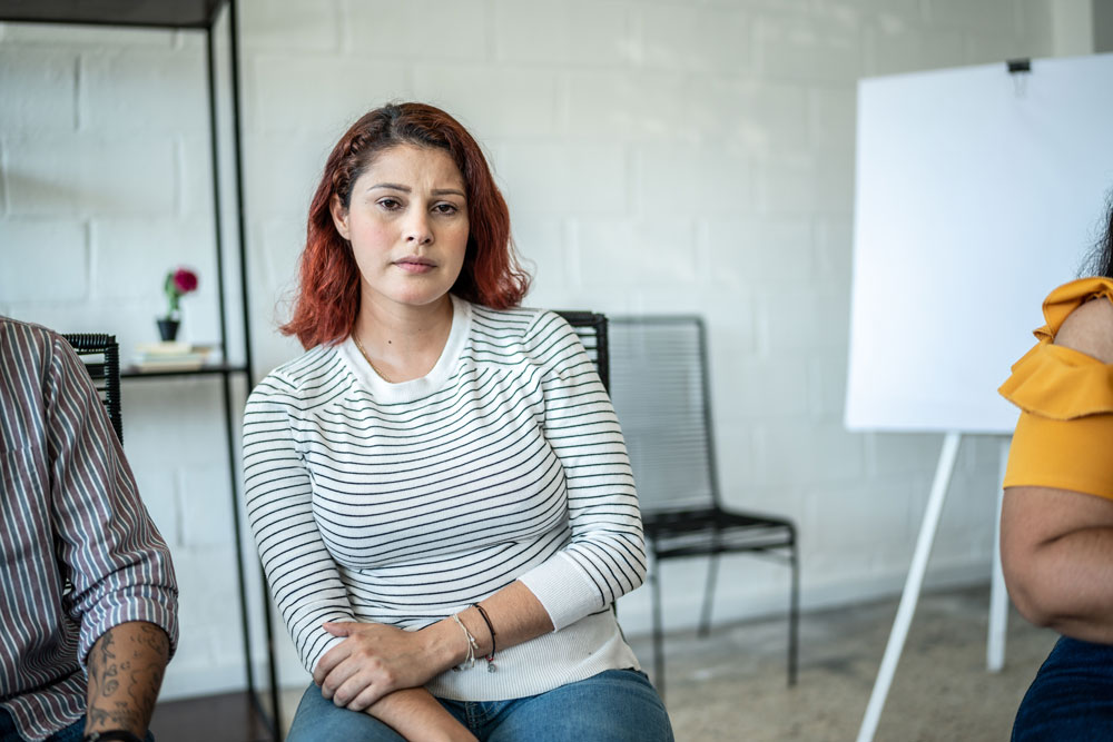 Woman in a group therapy session for sexual assault recovery