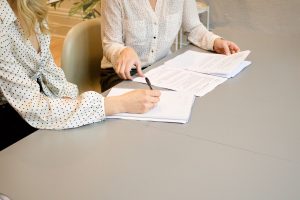 A woman signing initial documents to file for divorce