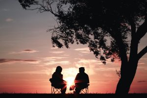 A couple sitting in a sunset after protecting retirement in bankruptcy